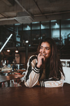 a shy young woman sitting in a coffee shop 