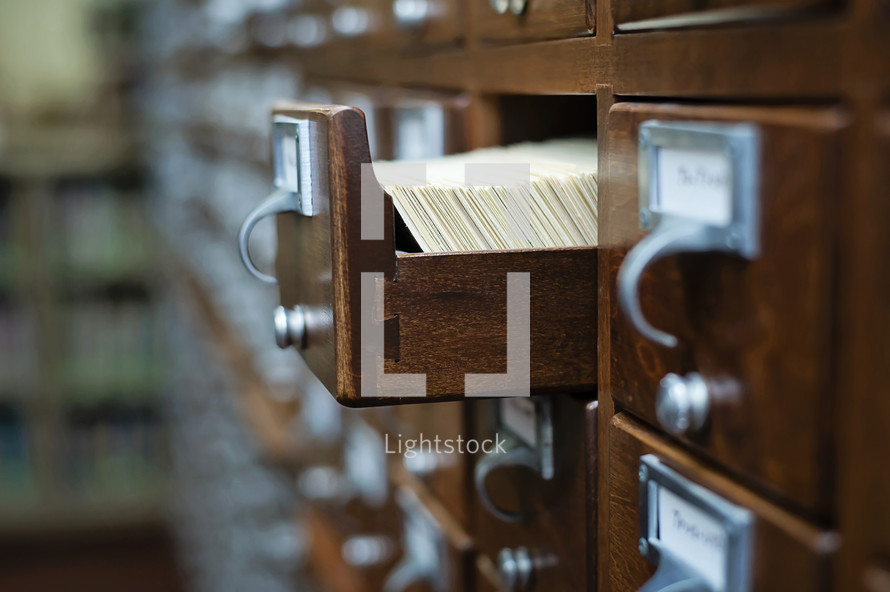 Library card catalog cabinet with an open drawer.