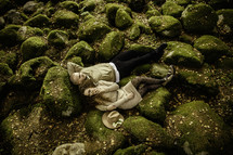 Couple laying down on moss covered rocks