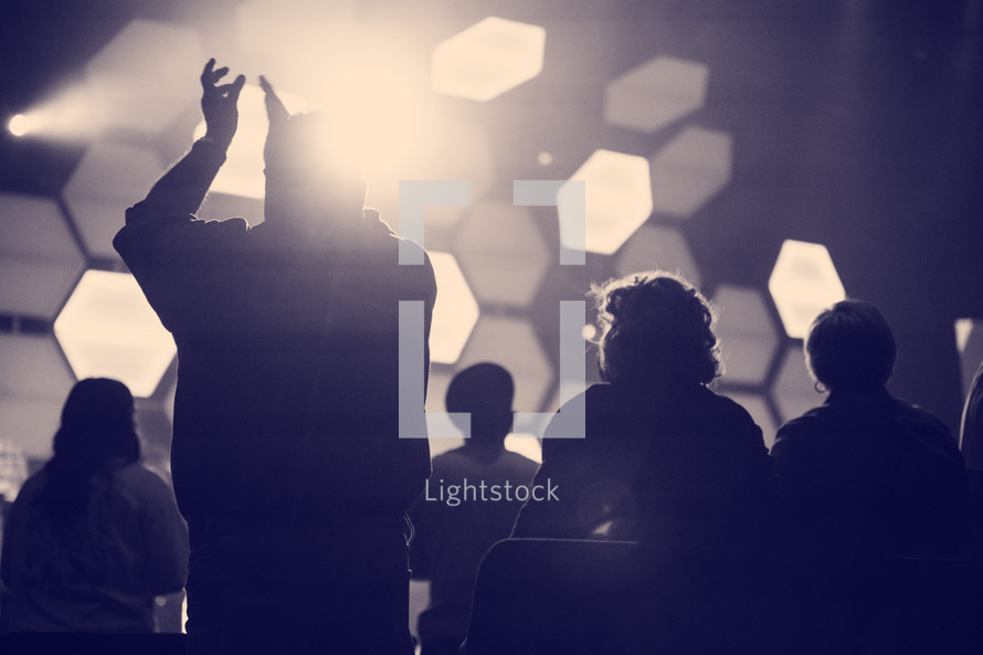 silhouttes clapping at a concert 