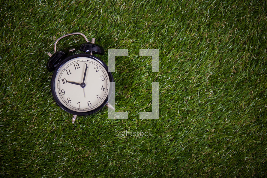 alarm clock in grass