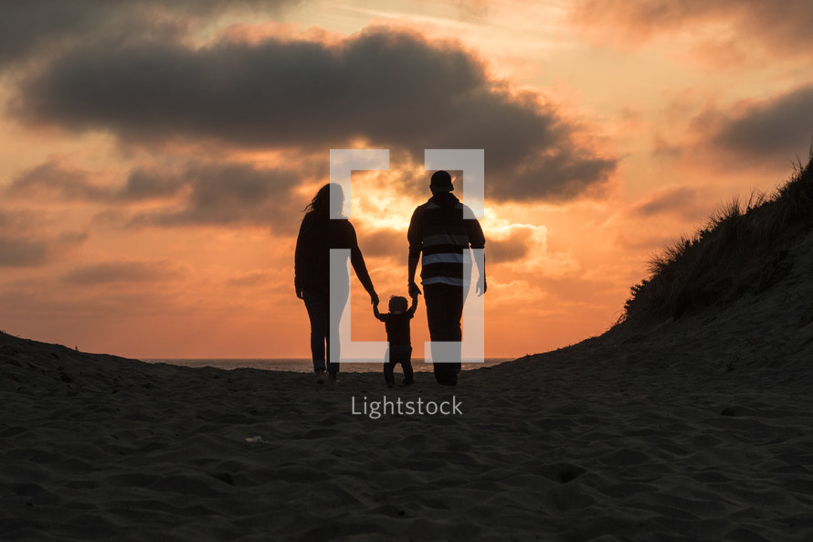 silhouette of a family on a beach at sunset in fall 