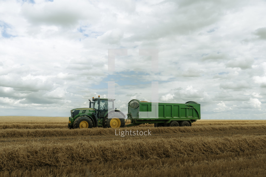 Tractor in a field, harvest time farming photo, rural countryside setting, agriculture