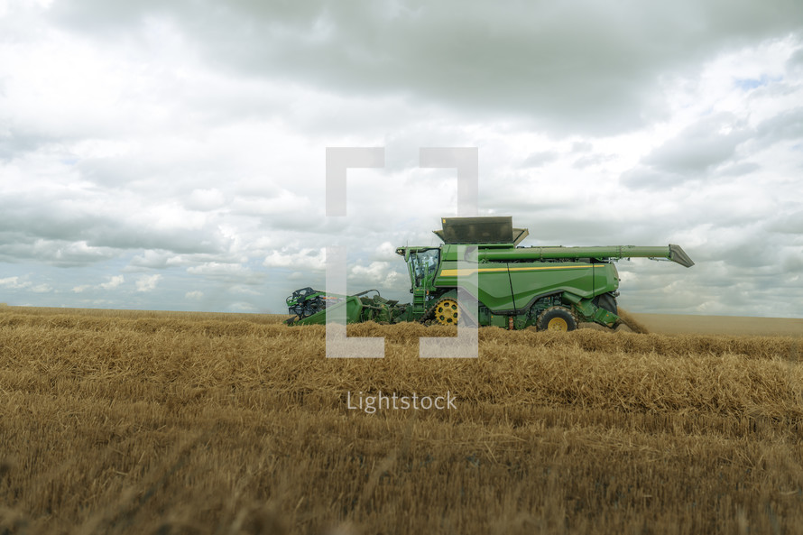 Combine harvester in a field, harvest time farming photo, rural countryside setting, agriculture