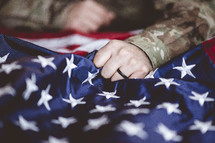 serviceman gripping an American flag 
