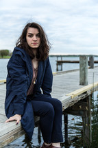 teen girl sitting on a wood dock 