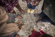 looking down at feet of a family standing in a circle 