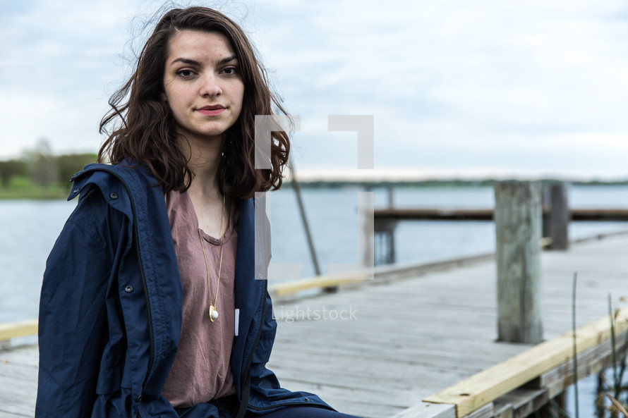 young woman sitting on a dock 
