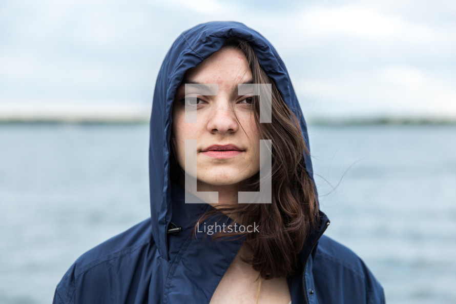 face of a brunette young woman in a hooded jacket 