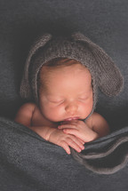 a sleeping newborn in a bunny hat 