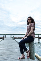 teen girl sitting on a wooden pier 