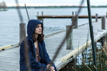 teen girl sitting on a wood pier 