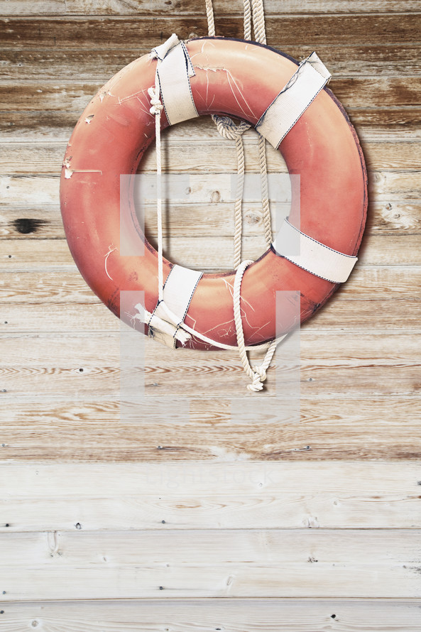 Lifesaver ring hanging on a wooden wall.