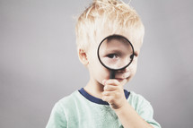 child looking through a magnifying glass