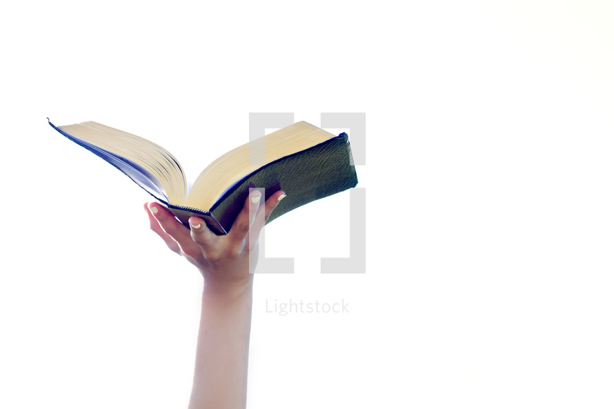 hand holding an open Bible in the air 