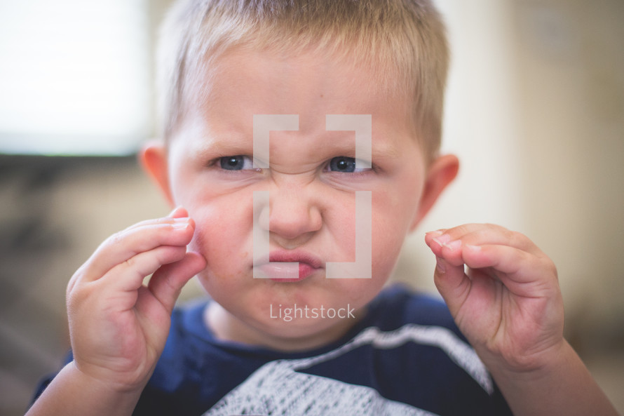 A young boy makes a silly face.