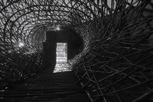 woven sticks to form a tunnel and hole near the door 