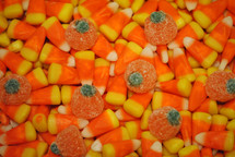 Candy corn and gumdrop pumpkins for Halloween or Thanksgiving; closeup, texture.