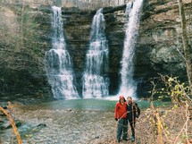 Friends posing near a waterfall.