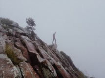Man standing at the edge of a rocky cliff.