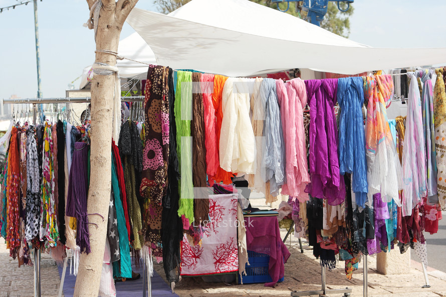 Colorful scarves hanging in an outdoor market.