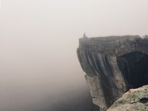 at the edge of a cliff and fog 
