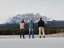 three men looking at a mountain 