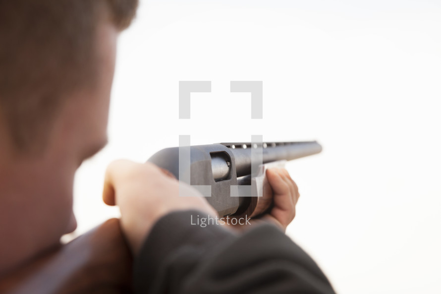 a man pointing a shotgun
