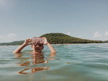 a boy with goggles in a lake 