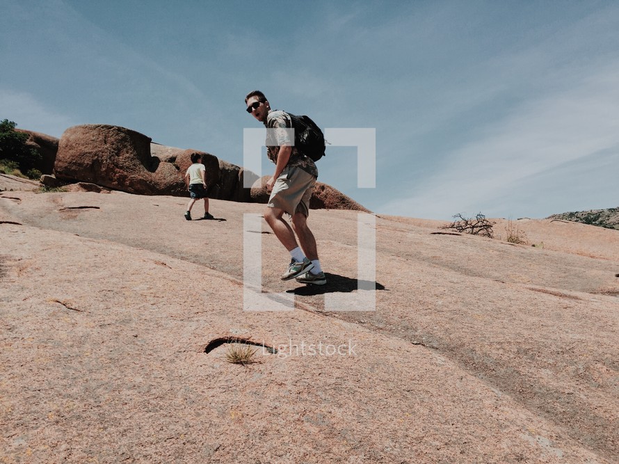 a man hiking up a rock slope 