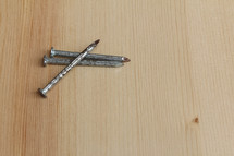 three nails on a wood background 