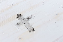 cross from ashes on white wood 