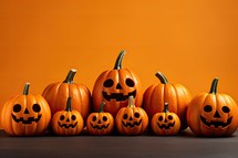 Halloween pumpkins with scary faces on orange background. Halloween concept