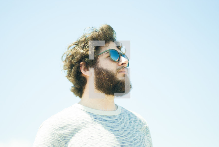 side profile of a man with a beard in sunglasses 