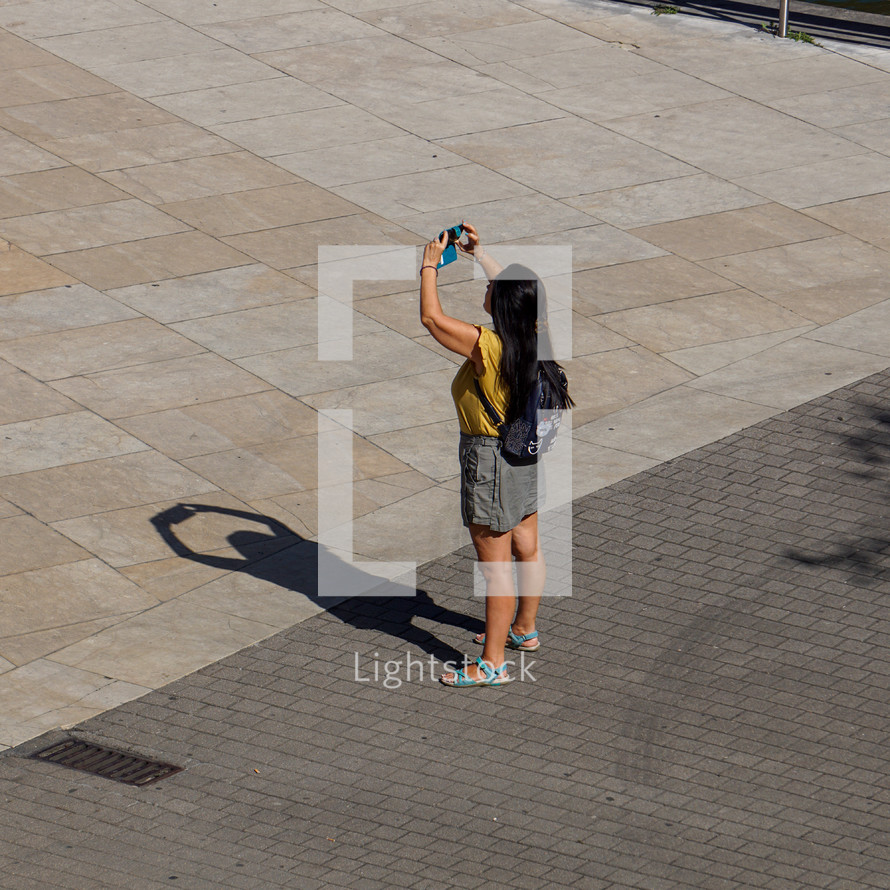 people on the street taking photos with a smartphone in Bilbao city, spain