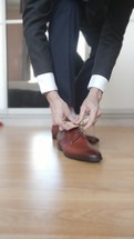 Blurred Businessman tying the shoelaces on his brown shoes