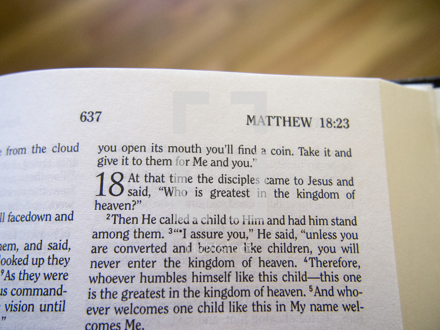 Bible open to Matthew 18:23.