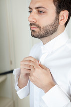 man getting ready buttoning his shirt 