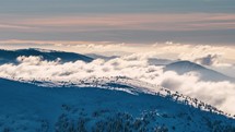 Misty winter mountains with fast clouds time lapse in sunset evening nature landscape
