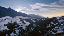Aerial panorama of winter countryside nature in evening mountains after sunset
