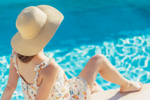 a woman sitting beside a pool 