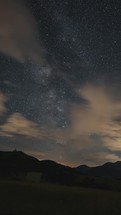 Vertical video of Milky way galaxy sky over mountains Time lapse panorama
