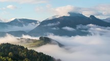 Foggy morning with wave of clouds in mountains valley landscape time lapse
