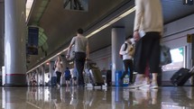 Timelapse of people rushing through a busy airport corridor