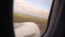 Airplane wing is seen through its window while flying. Airplane, Aircraft. Traveling by air.	
