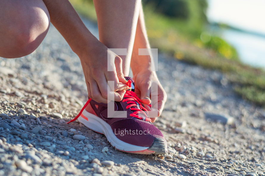 a woman tying her shoe laces before a jog