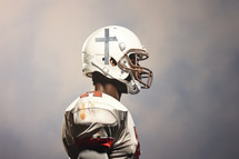 Team Jesus. Rear view of an African American football player wearing a helmet with a cross.