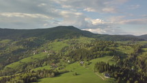 Aerial view of green spring countryside in Carpathian mountains in sunny evening
