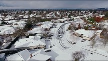 Aerial View Flying Over Snow-Covered Town With Kids Playing in the Street