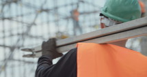 Construction worker carrying scaffolding in a construction site